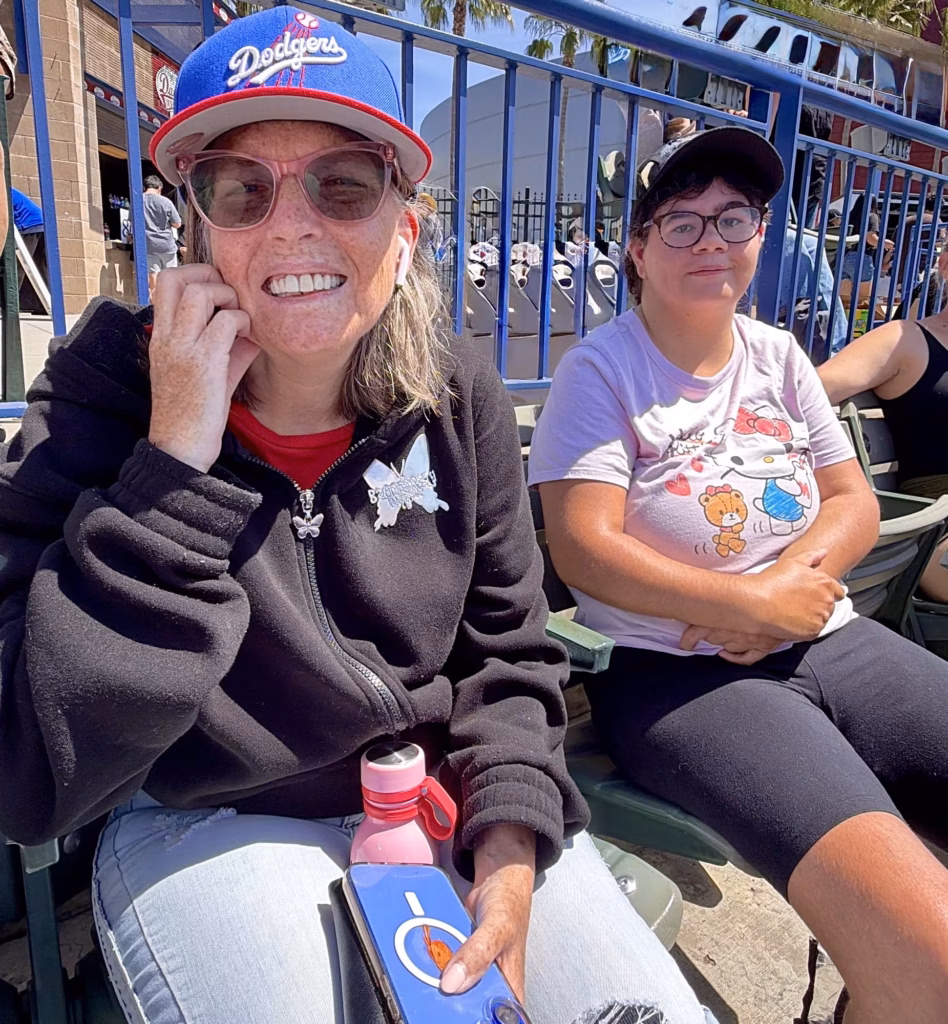 Two Compass participants smiling at a baseball game