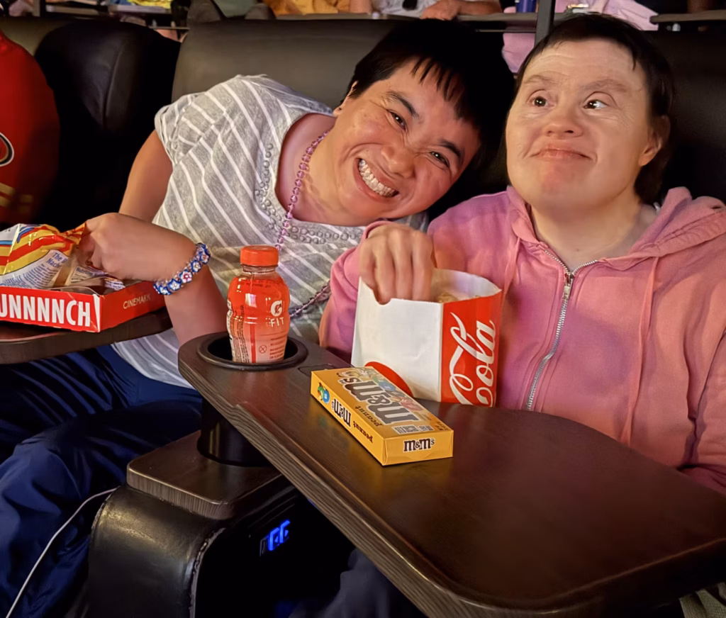 Two Compass participants laughing together at the movies