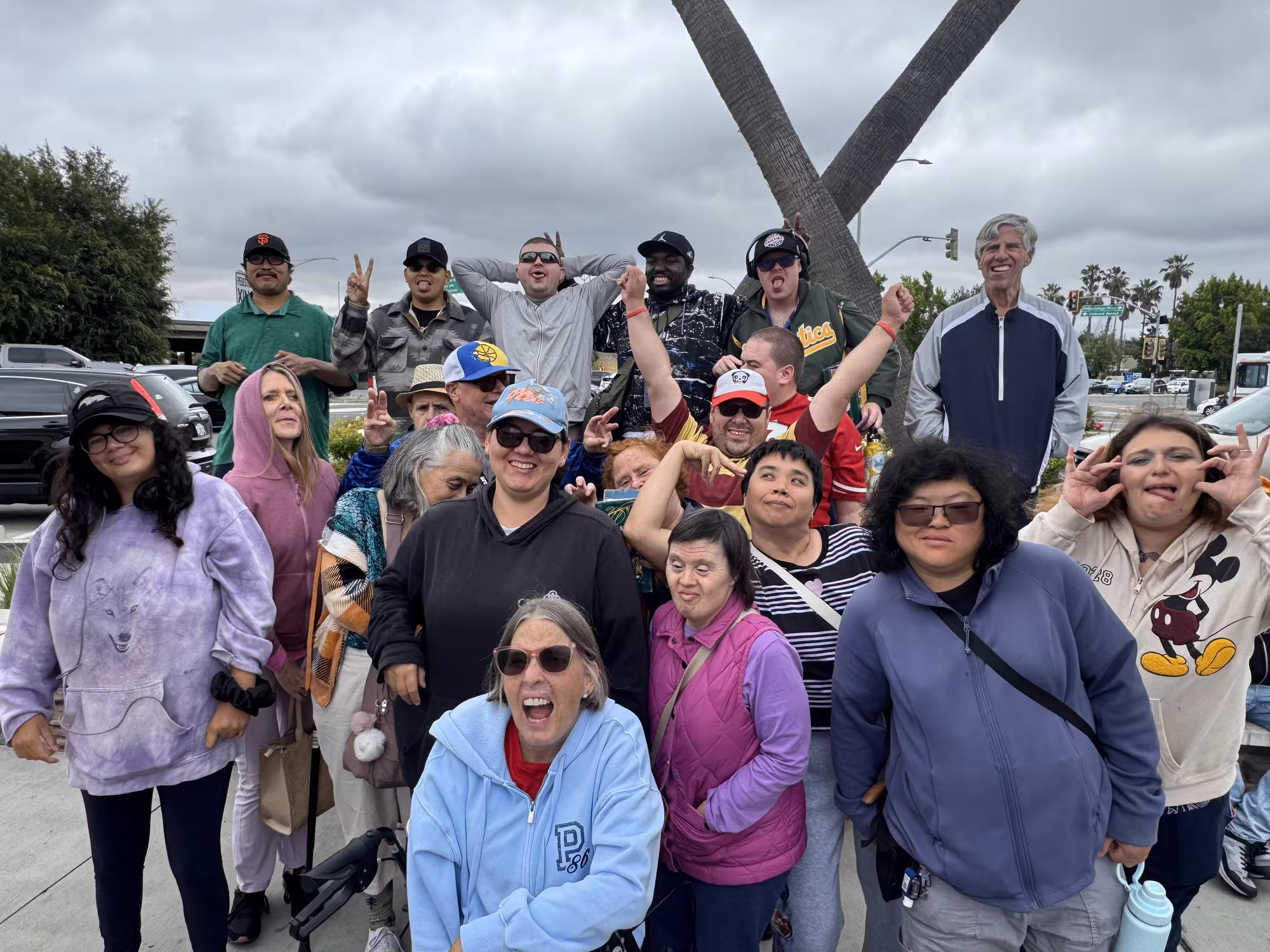 A large group of Compass participants and staff smiling together outdoors